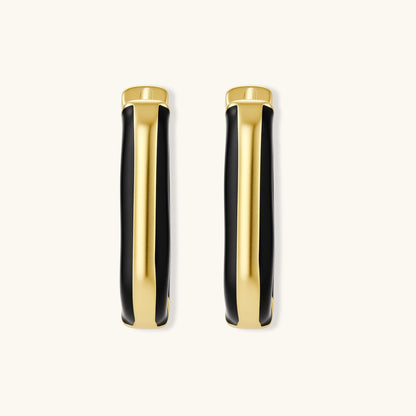 Modern hoop earrings with gold-plated and black sections, featuring hinged closure on white background.